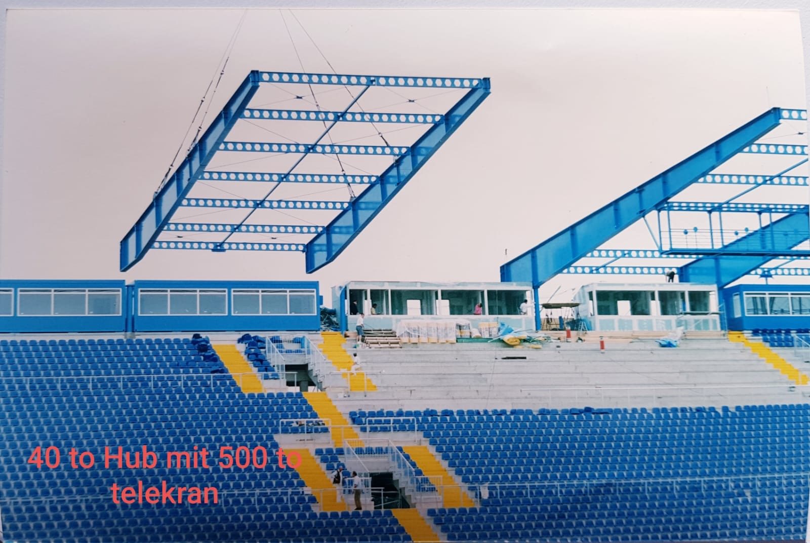 Montage von Stahlbauteilen über den Tribünen eines Stadions